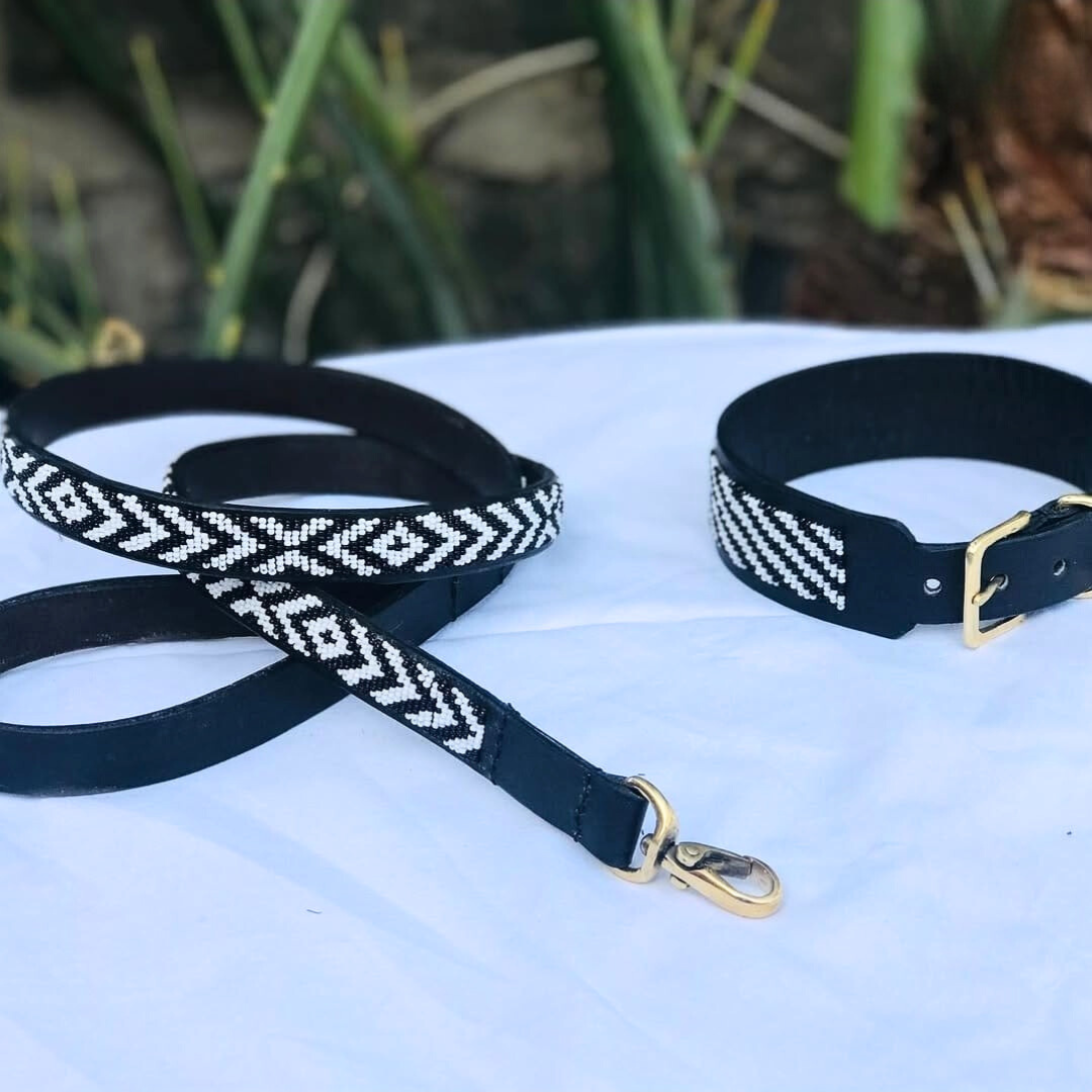 Beaded Black dog collar and leash with white patterns on a light surface.