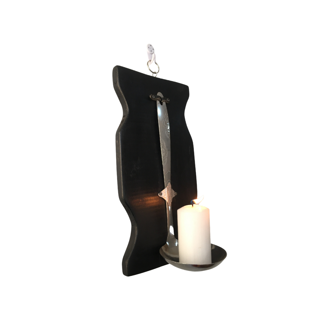 Uniquely curated candle stands with a repurposed serving spoon