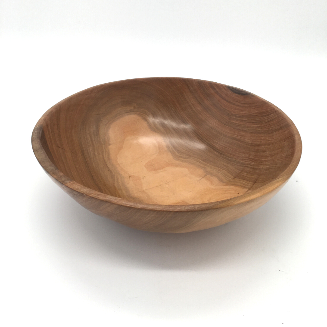 A round, wooden salad bowl with a natural beige finish.